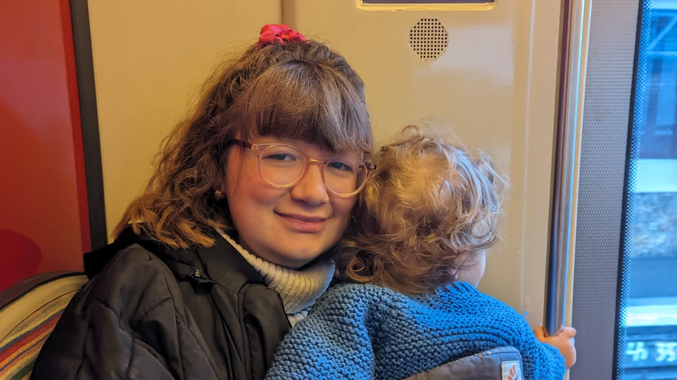 Megan Downs and her young son on the train to the airport in Paris after their train was cancelled.