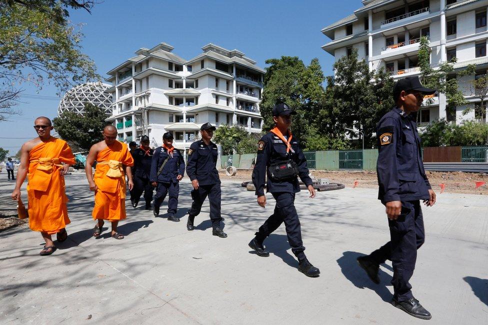 Policemen and Buddhist monks search for a fugitive Buddhist monk inside Dhammakaya temple in Pathum Thani province, Thailand February 17, 2017.