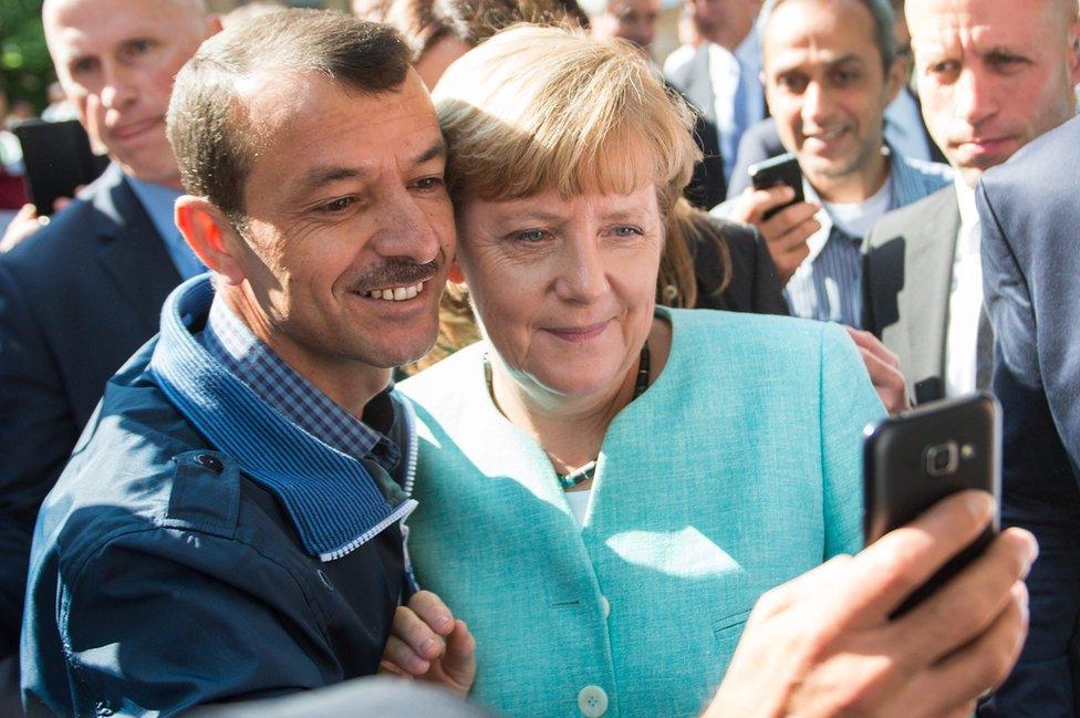 Angela Merkel poses for selfie with a man seeking asylum at a reception centre in Berlin (9 Sept)