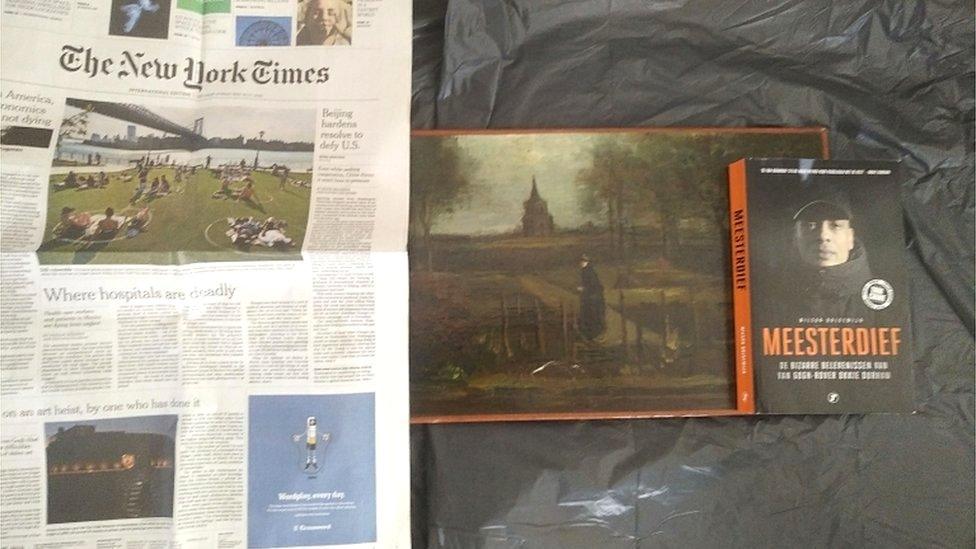 What is believed to be the missing painting is shown next to a dated copy of the New York Times and a book