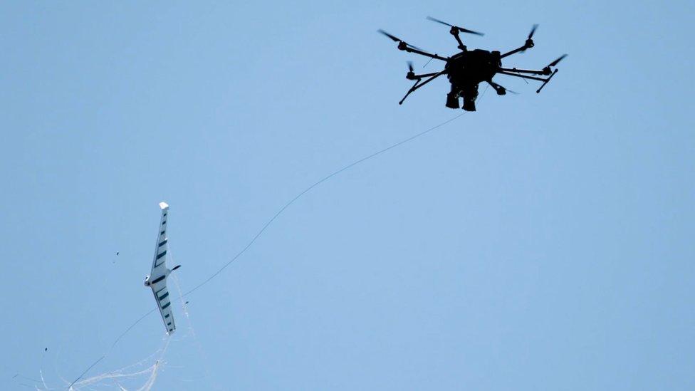 A drone interceptor capturing a fixed wing drone