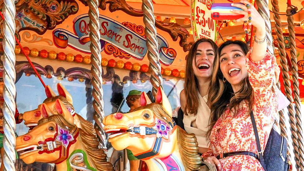 Two visitors pose on a carousel in Brighton, England, on 31 May 2021