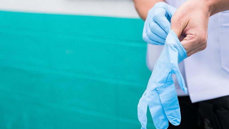 Care worker putting on gloves