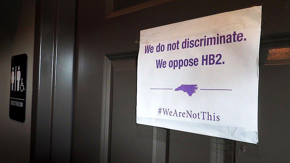 A unisex sign and the 'We Are Not This' slogan are outside a bathroom at Bull McCabes Irish Pub on May 10, 2016 in Durham, North Carolina.