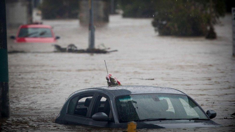 Submerged cars sit abandoned in a flooded carpark in Toombul, in Queensland on March 30, 2017. Torrential rain hampered relief efforts after powerful cyclone Debbie wreaked havoc in northeast Australia, with floods sparking emergency rescues as fed-up tourists began evacuating from resort islands