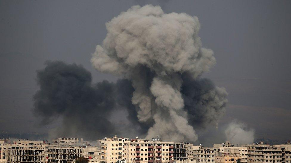 A picture taken on 20 February 2018 shows smoke plumes over the besieged Eastern Ghouta region in Syria