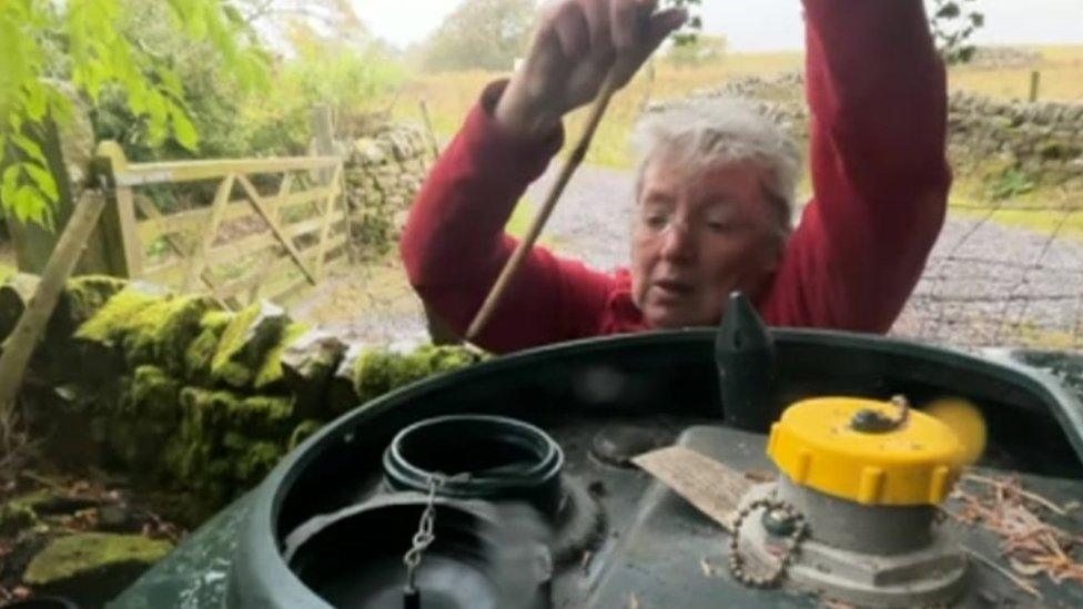 Alice checks the level of her oil storage drum