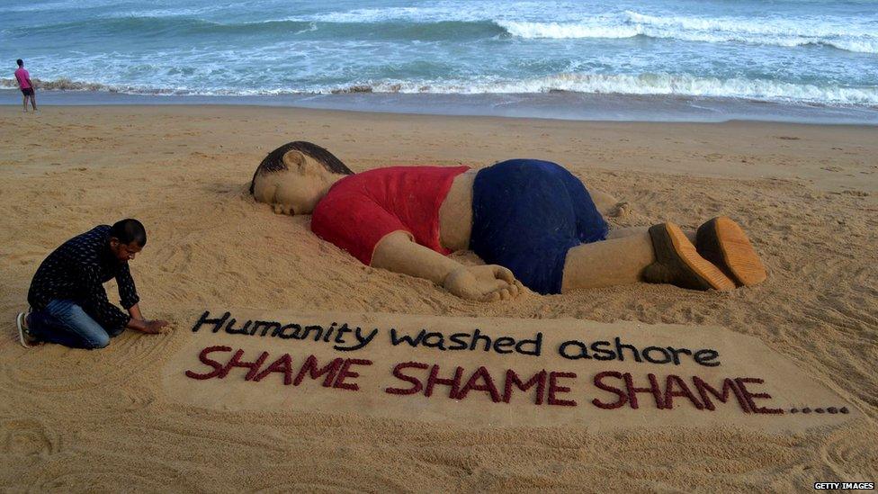 Indian artist Sudarsan Pattnaik works on a sand sculpture depicting drowned Syrian boy Alan Kurdi at Puri beach, some 65 km away from Bhubaneswar, on September 4, 2015.