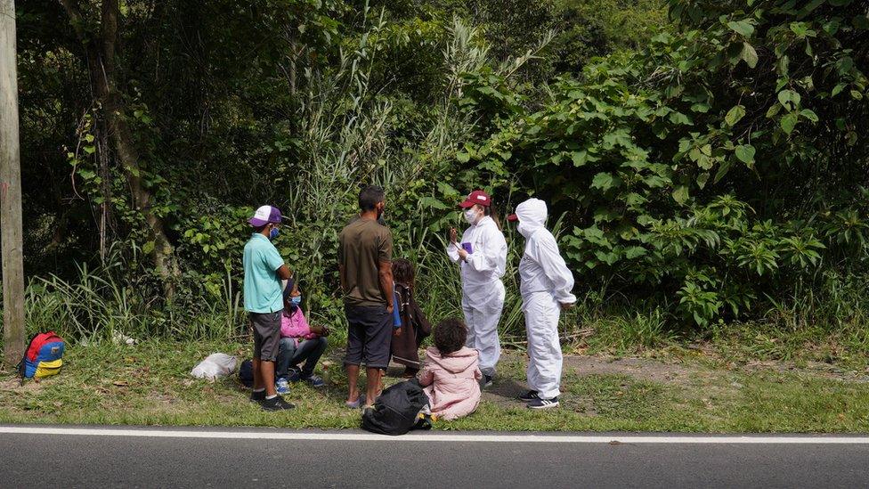 Workers from humanitarian group Consornoc approach migrants outside Pamplona and give them information on the road ahead.