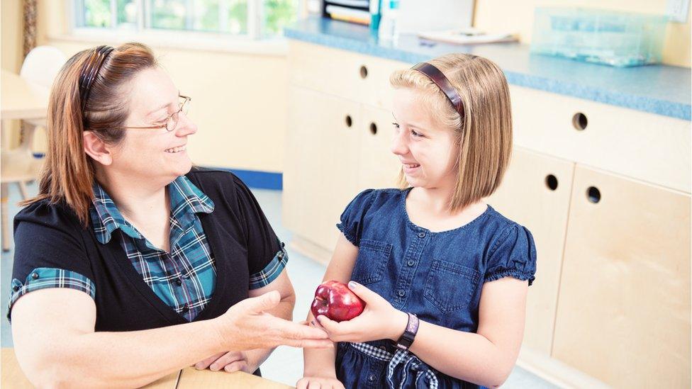 Child gives teacher an apple