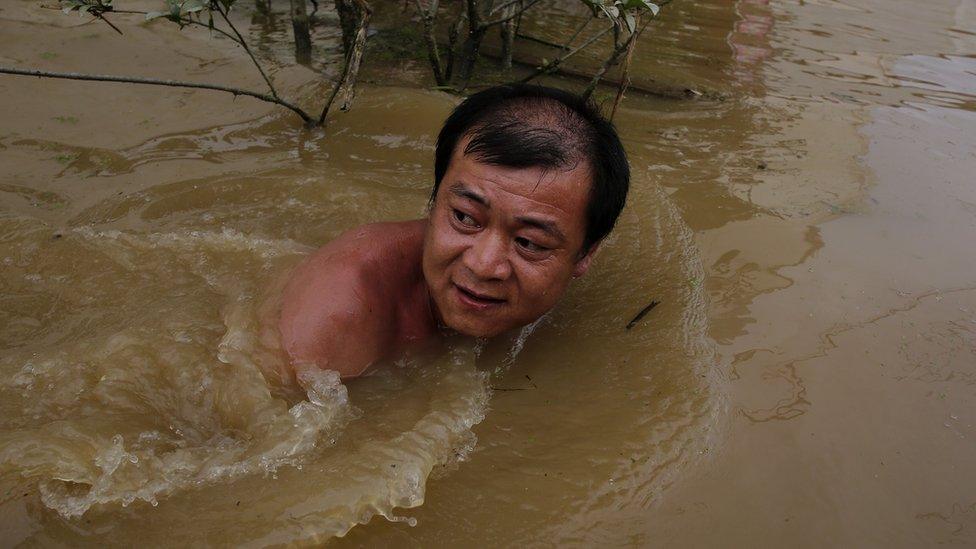 Villager swimming in floodwater in Wuhan