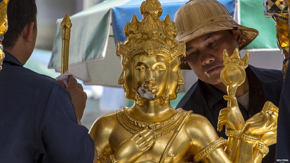 Shrine workers clean the statue of Brahma at the Erawan Shrine in Bangkok (19 Aug 2015)