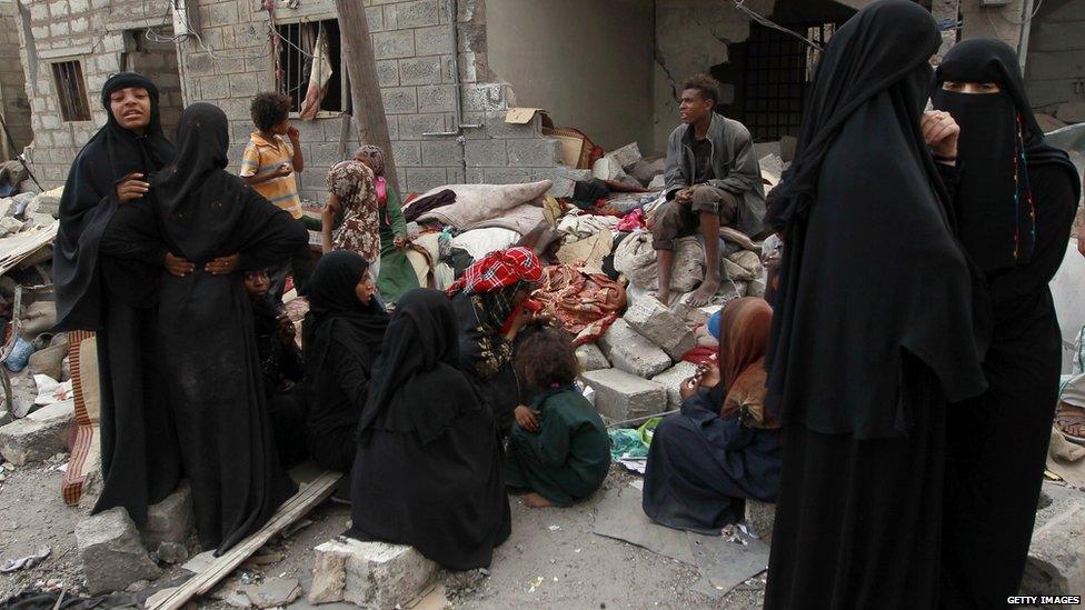 Yemenis gather amid the ruins of a building damaged in an air-strike by the Saudi-led coalition on the capital Sanaa on 13 July, 2015.