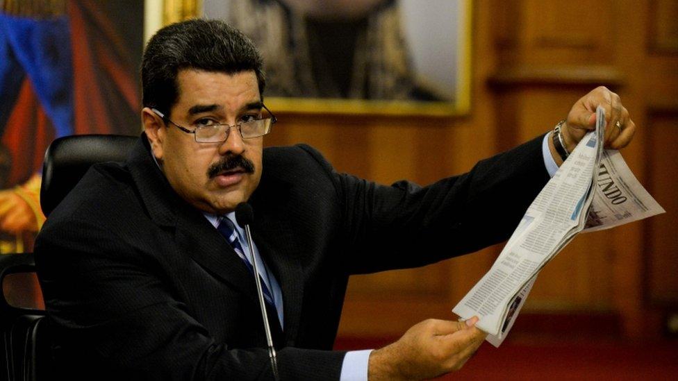 Nicolas Maduro holds a copy of a Spanish newspaper during press conference in Caracas