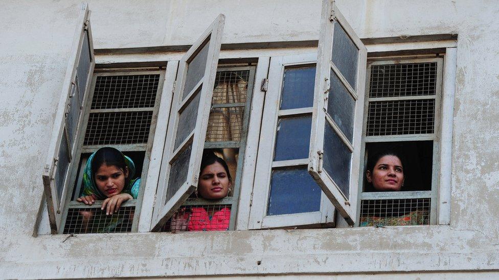 Pakistani women watch celebration from window of a building in Islamabad