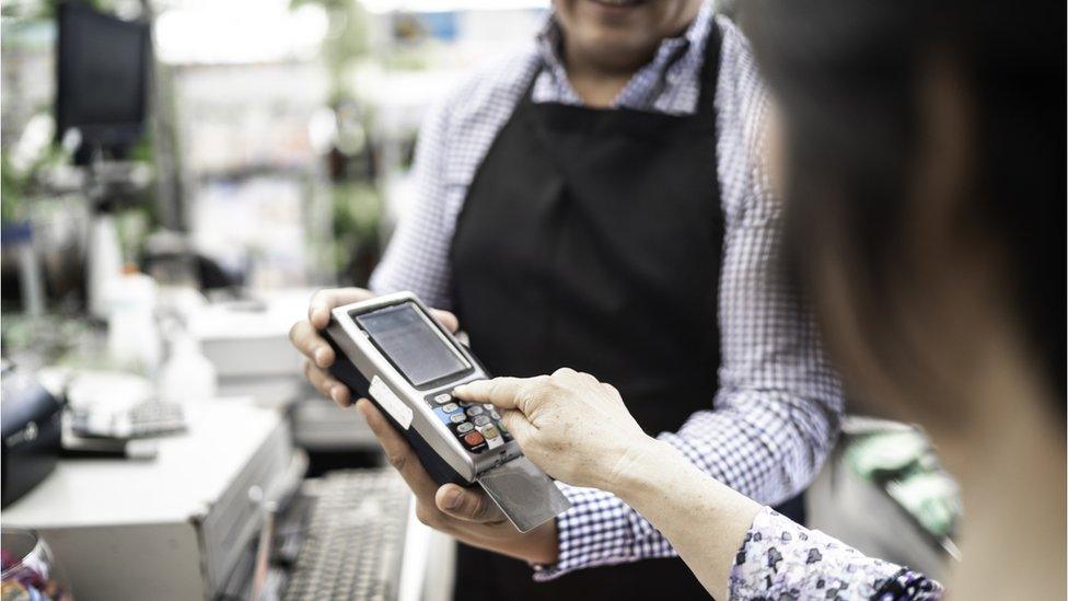 Woman using a debit card machine