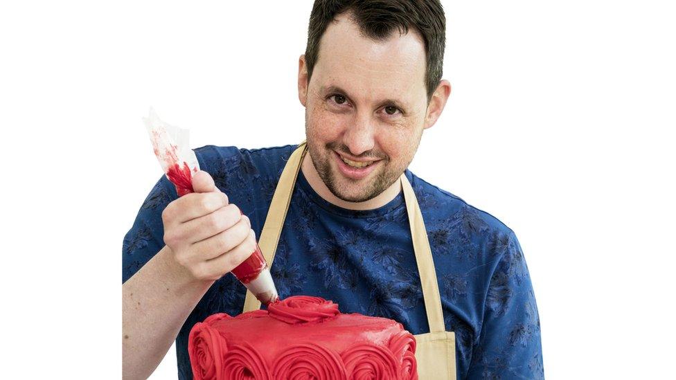 Dan ices a red cake with roses