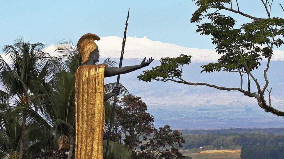 This Jan. 31, 2014, file photo, shows a statue of Hawaiian King Kamehameha I with snow-capped Mauna Kea in the distance, in Hilo, Hawaii.