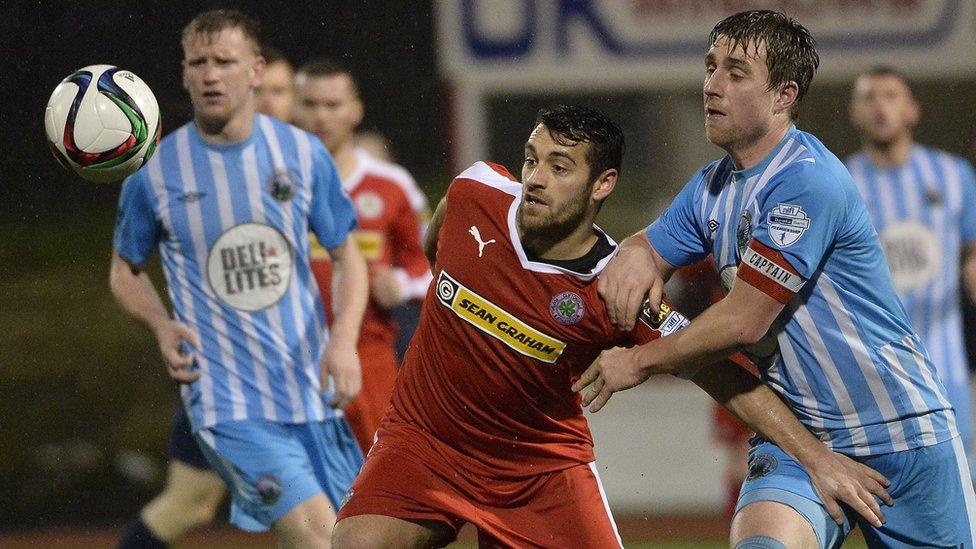 Cliftonville striker David McDaid tries to hold off Warrenpoint Town opponent John Boyle at Solitude