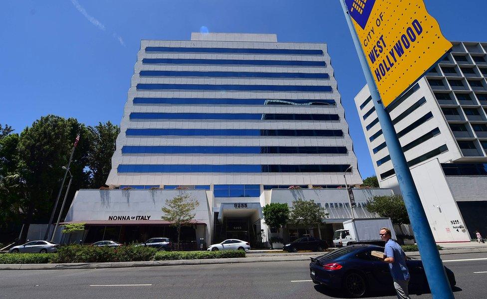 A pedestrian crosses the street across from the building on Sunset Boulevard in West Hollywood, California on 20 July 2016, where Red Granite Pictures has an office on the seventh floor.