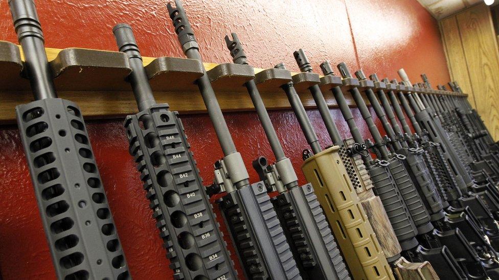 In this July 20, 2012, file photo, a row of different AR-15 style rifles are displayed for sale at the Firing-Line indoor range and gun shop in Aurora, Colo