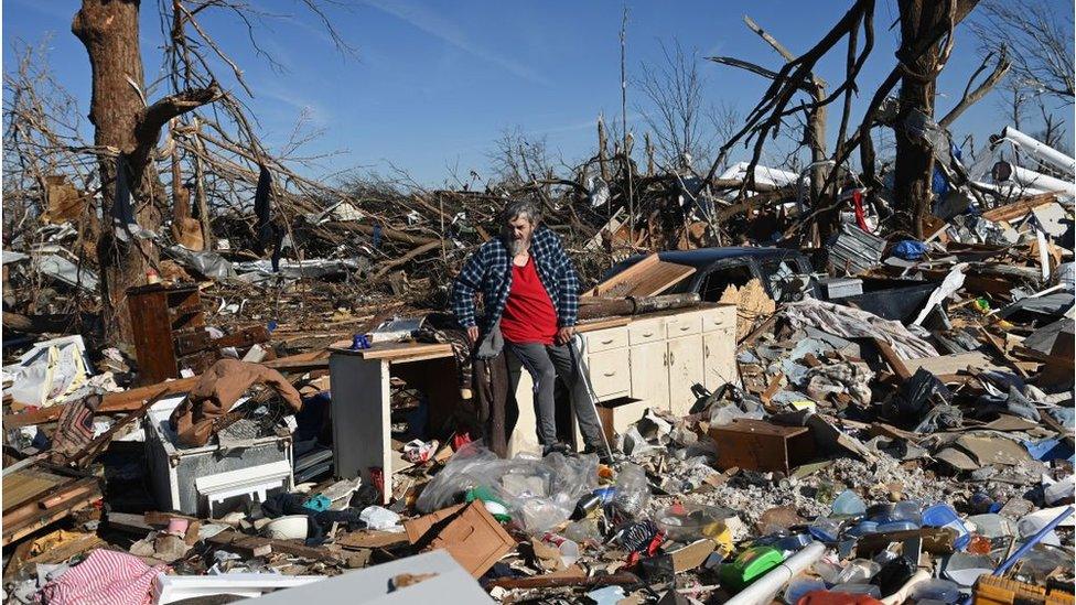 A man in Mayfield surveys damage to a neighbourhood