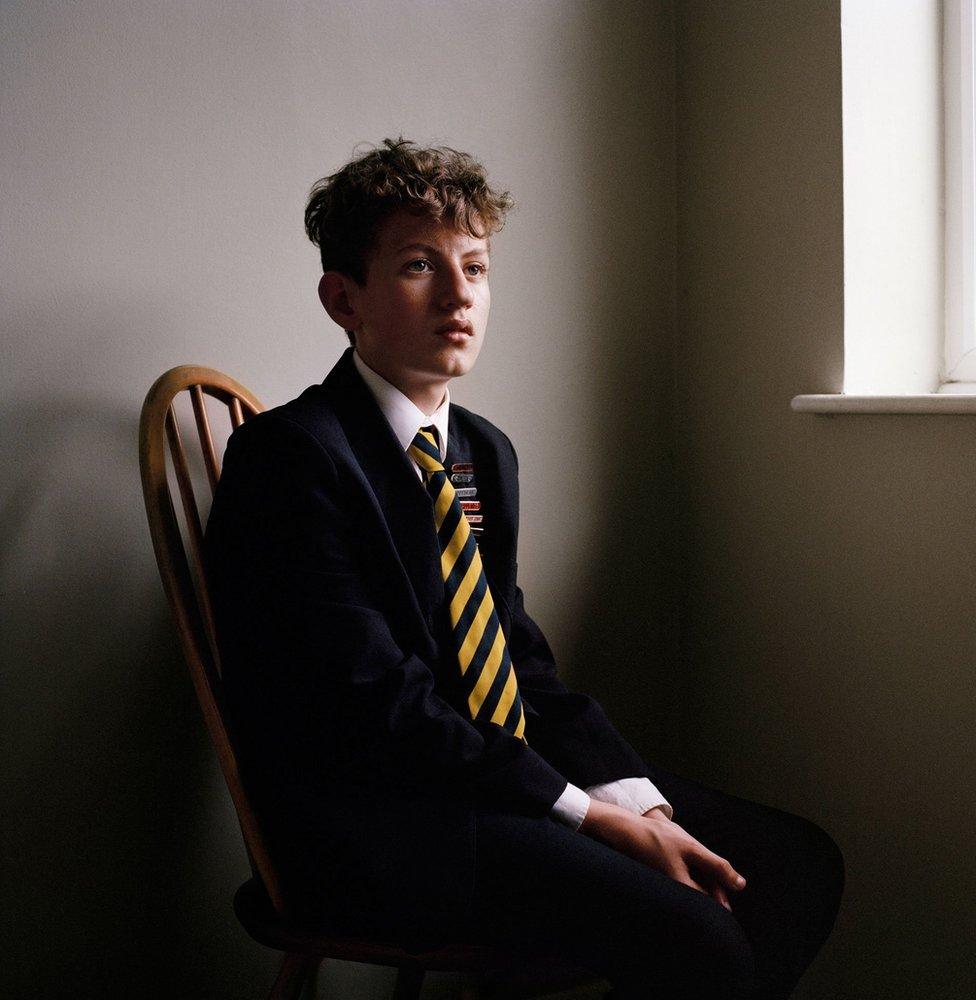 A school boy sitting on a chair