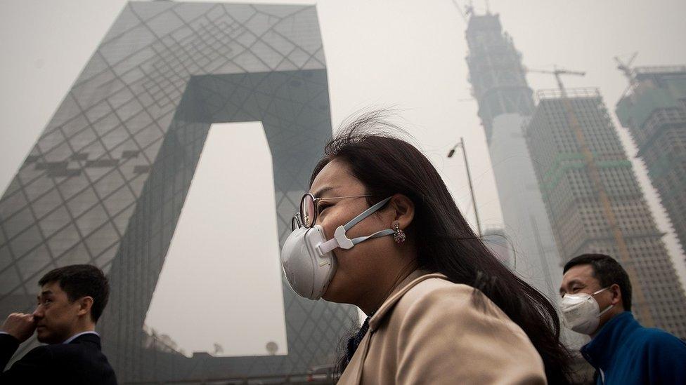 Woman wearing anti-pollution mask in smoggy Beijing