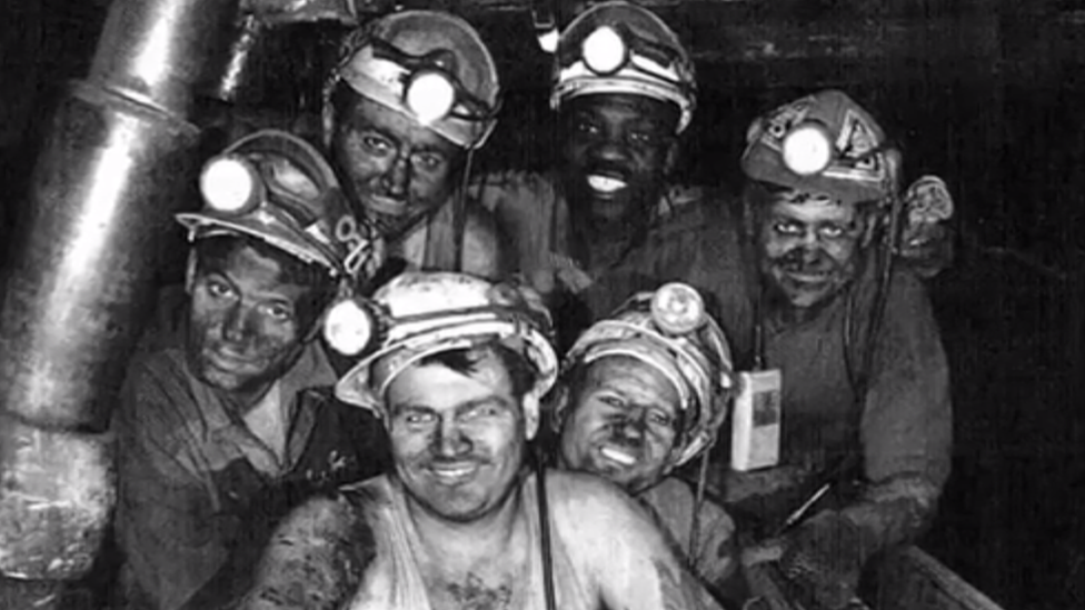 Black miner with white colleagues