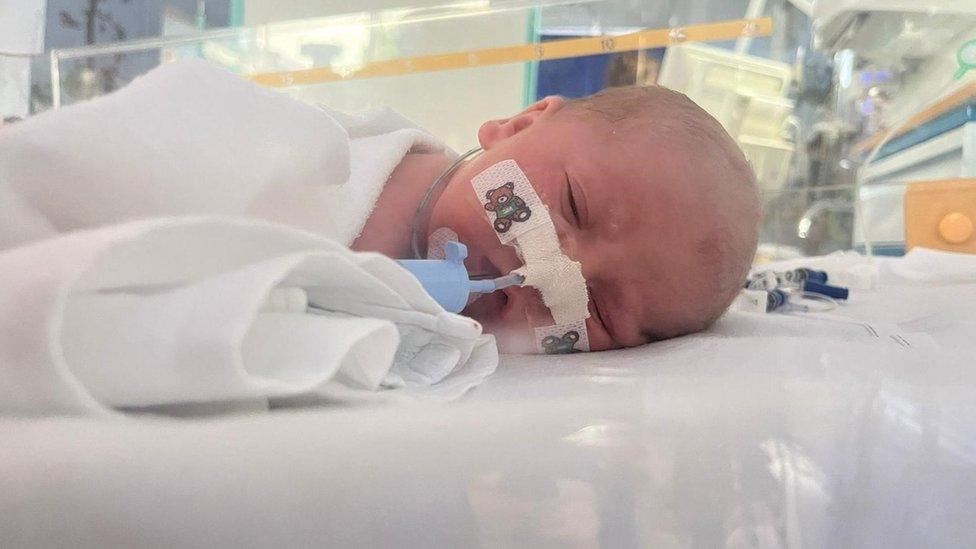 A baby in an incubator with a ventilator