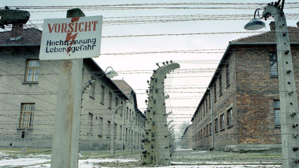 Barbed wire fence around prisoner barracks at former Auschwitz-Birkenau death camp - file pic