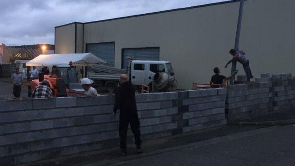 Local residents building a wall at the entrance of a disused hotel in Séméac. Photo: 24 July 2017