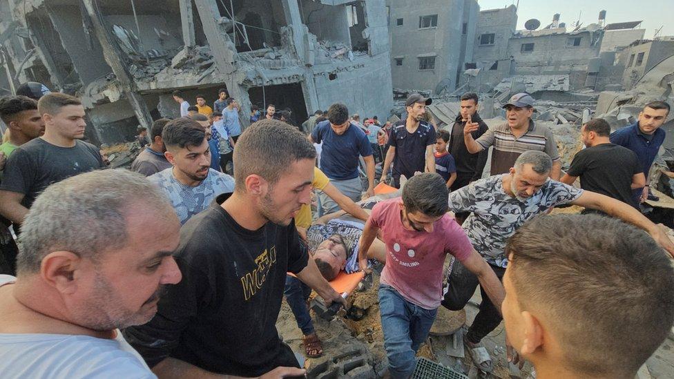 Palestinians evacuate a casualty after a reported Israeli air strike in Jabalia refugee camp, in the northern Gaza Strip (31 October 2023)