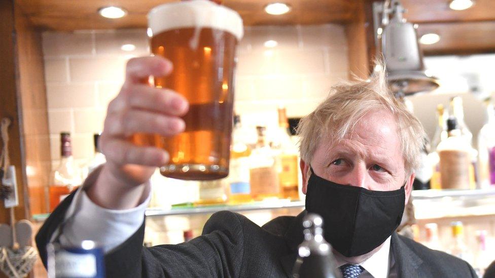 Boris Johnson holding a pint of beer in a pub