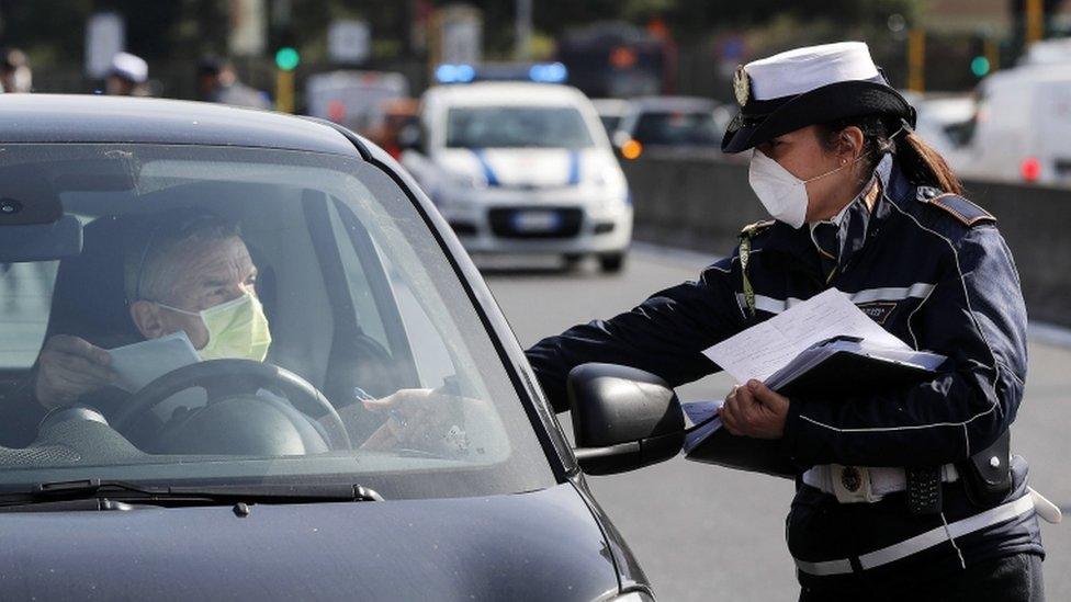 Police officer checking documents of a driver in a car