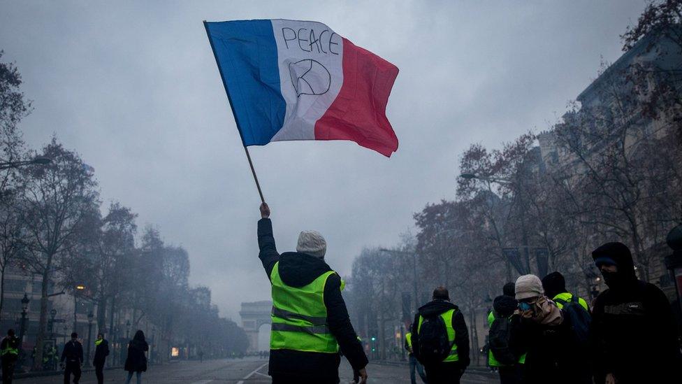 A protester waves a flag during the "yellow vests" demonstration in Paris France