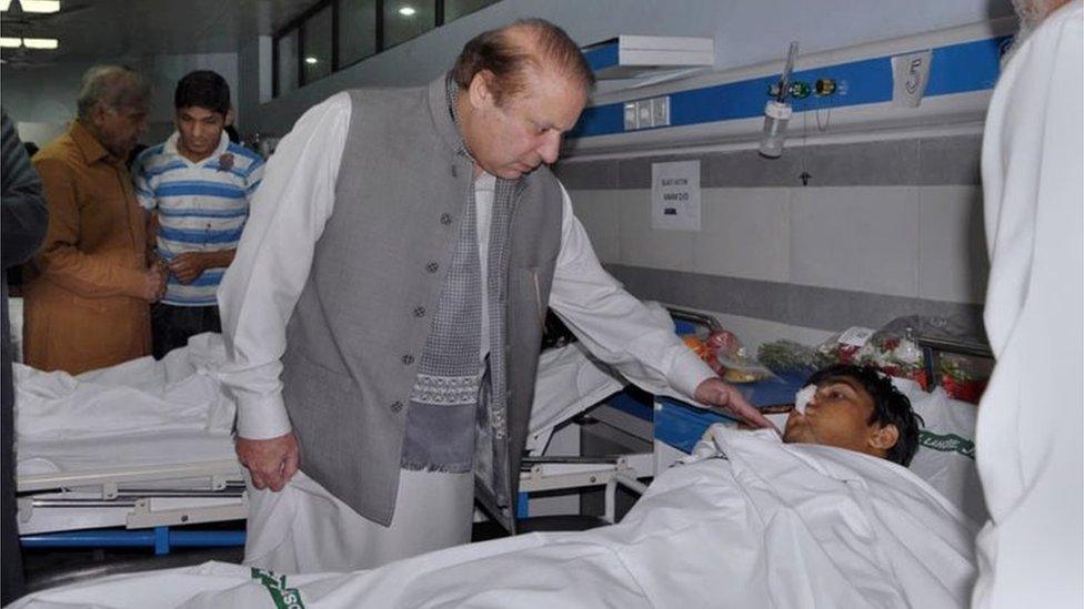 Pakistan's Prime Minister Nawaz Sharif talks to an injured victim of Sunday's suicide bombing during his visit to a local hospital in Lahore, Pakistan, Monday, March 28, 2016.