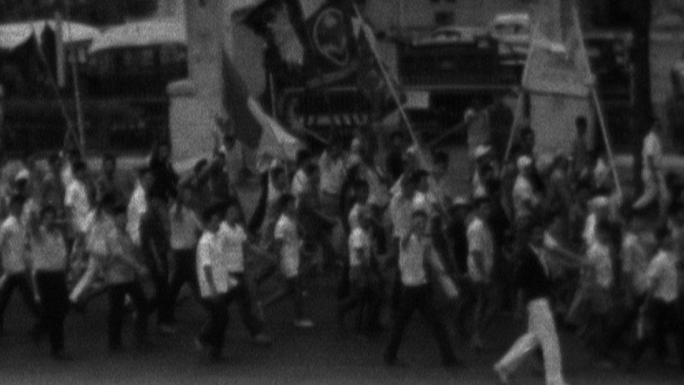 Black and white footage of a political march from the time.