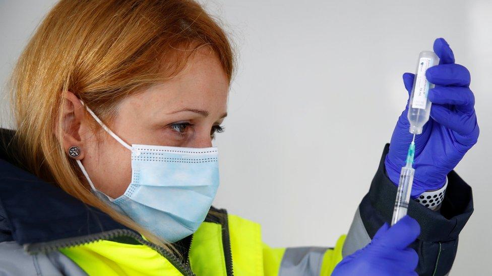 Lead Pharmacist Alina Barbu prepares a dose of Pfizer vaccine at a vaccination centre