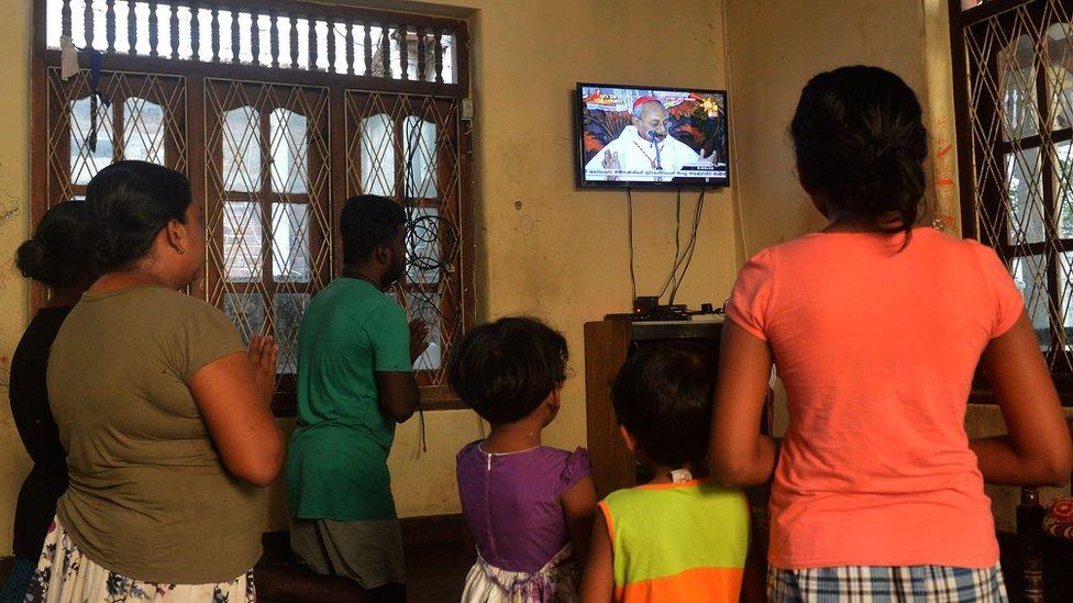 Family in Negombo praying and watching Archbishop of Colombo's service on TV