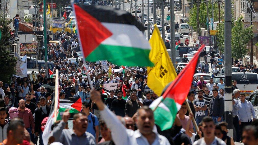 Palestinians take part in a protest in solidarity with Palestinian prisoners held by Israel