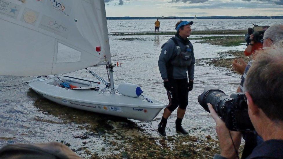 Dr Andrew Hill-Smith pulling his boat ashore