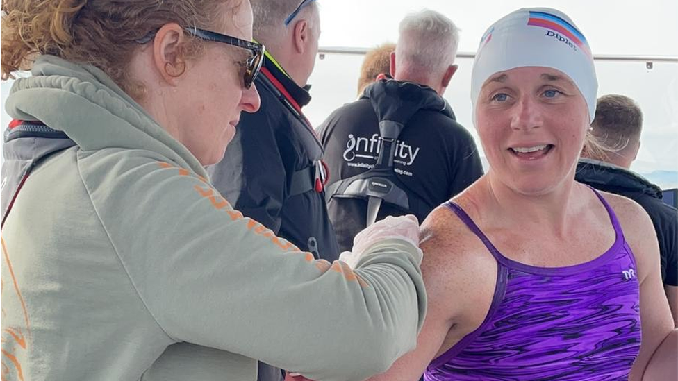 Jane Reilly preparing Gillian Segasby with skin protection ahead of the swim