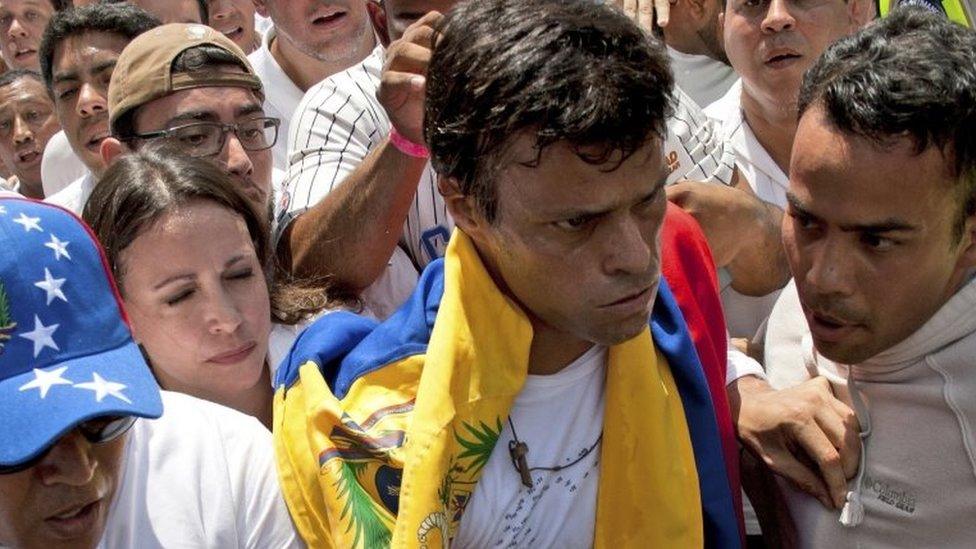 In this file photo from 18 February, 2014, opposition leader Leopoldo Lopez (second from right) draped in a Venezuelan national flag is about to hand himself in to national guards, in Caracas, Venezuela