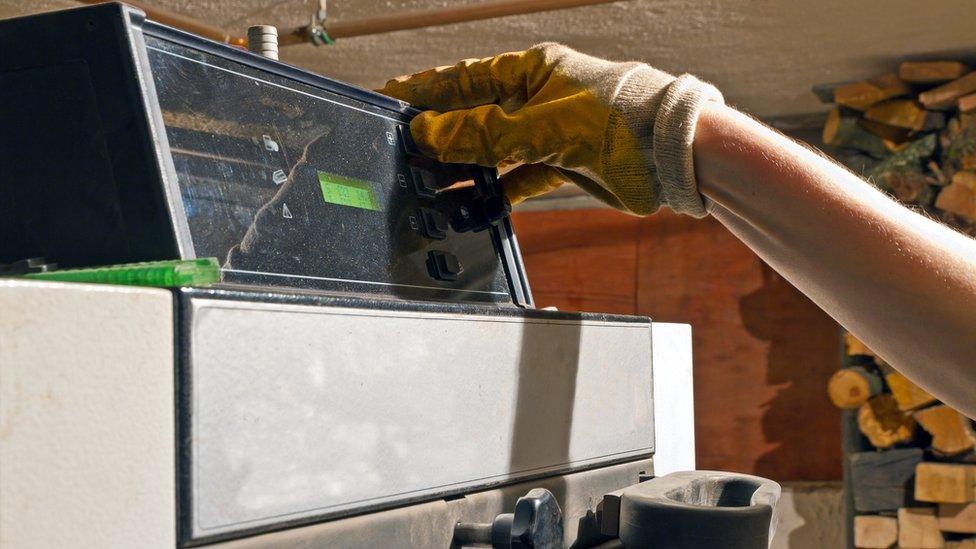 A man operates a biomass boiler