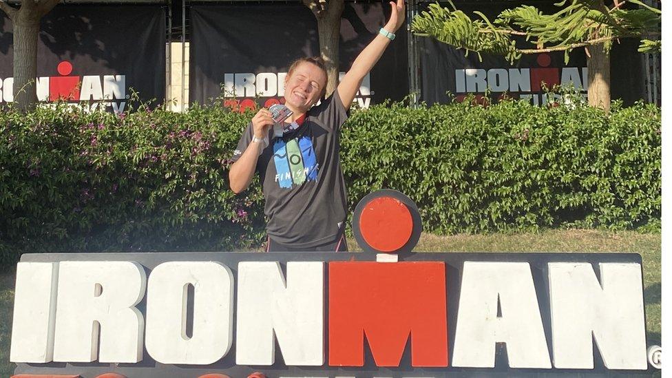 Megan Hamill standing in front of an Ironman sign