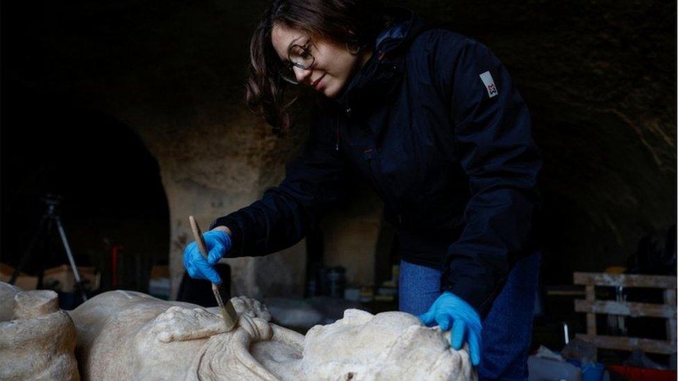 Archaeologist restoring the statue