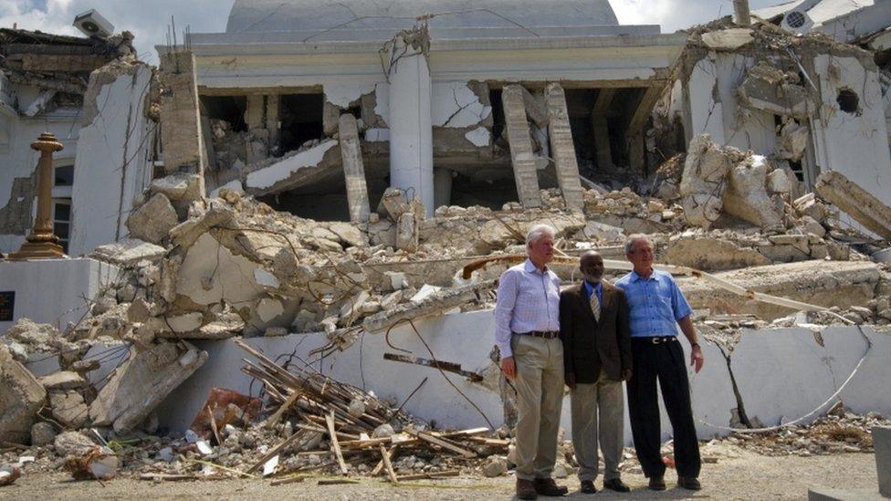 Rene Preval stands next to former US presidents Clinton and Bush outside the presidential palace two months after the 2010 quake, March 22 2010