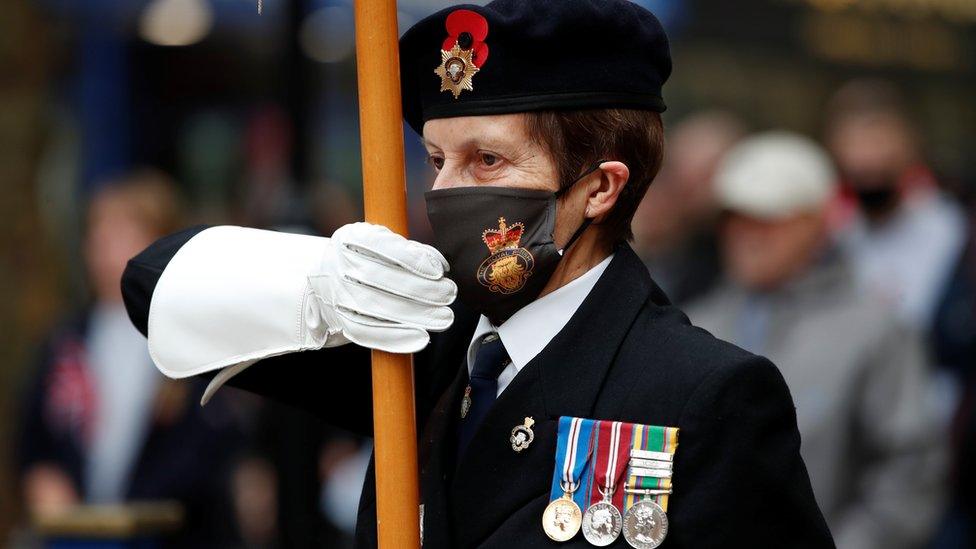 A veteran holds a British flag at the Peterborough War Memorial