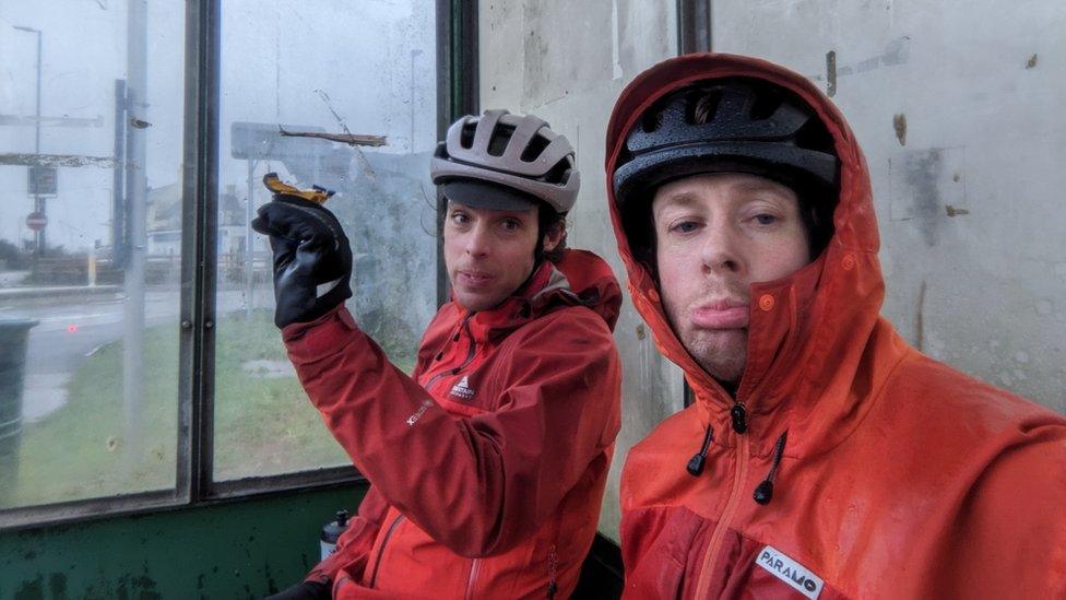 Cyclists sitting down in a shelter